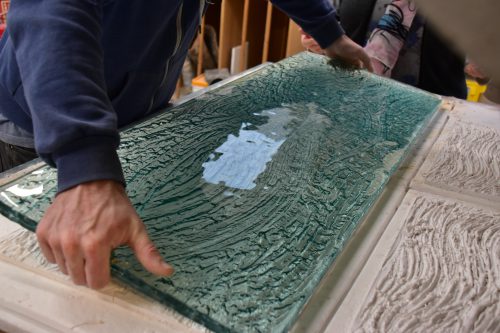 Float glass is laid on top of the plaster mould to create the kiln formed glass surface.