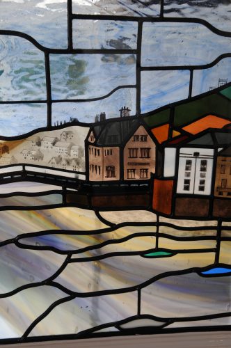 Close up of stained glass featuring town and water