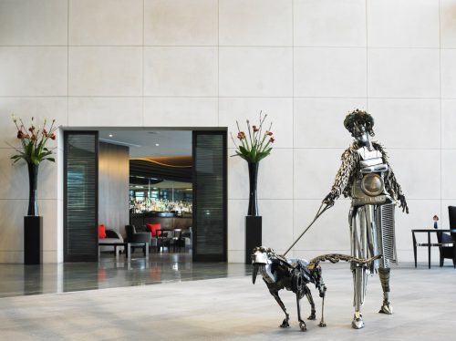 Brooklands exterior with dog walker sculptor and glass screens
