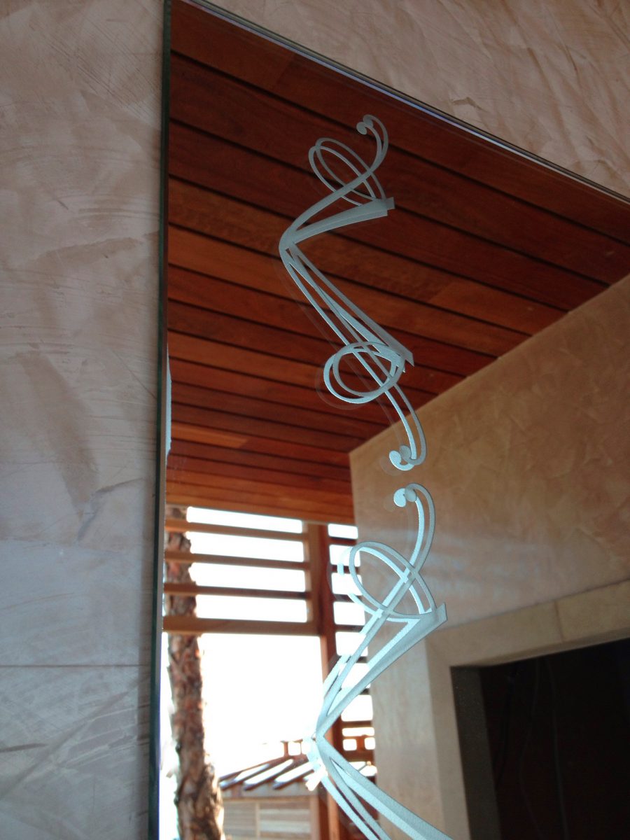 Different mirrors featuring sandblasted borders and etched logos are situated in the basement games room, the dance room, the master bedroom, and guest bedrooms.