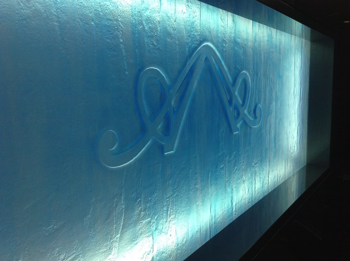 Close up of double A logo on the back painted, kiln-formed glass panel in the entertainment room.
