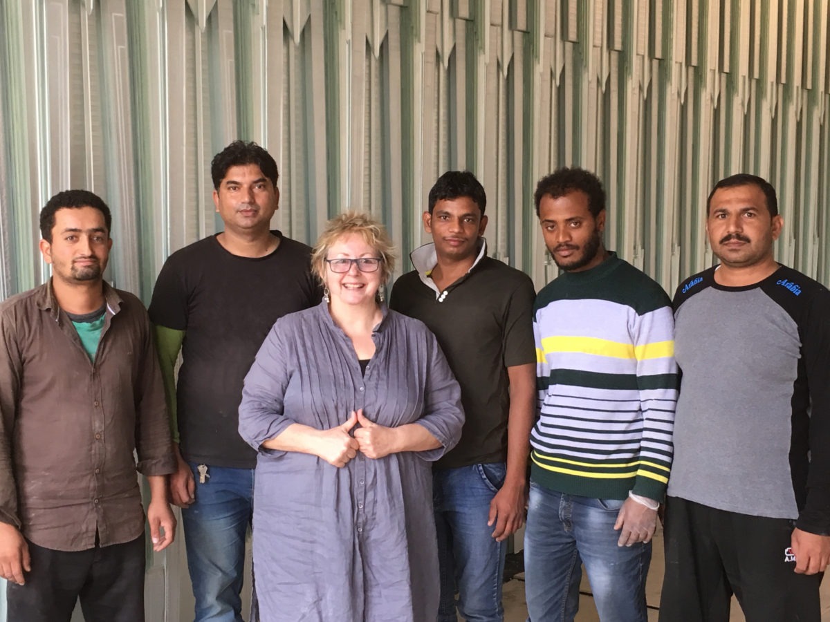 Daedalian Glass Studios Founder, Davia Walmsley with local contractors in front of the completed glass Majlis Wall for the Royal Palace.